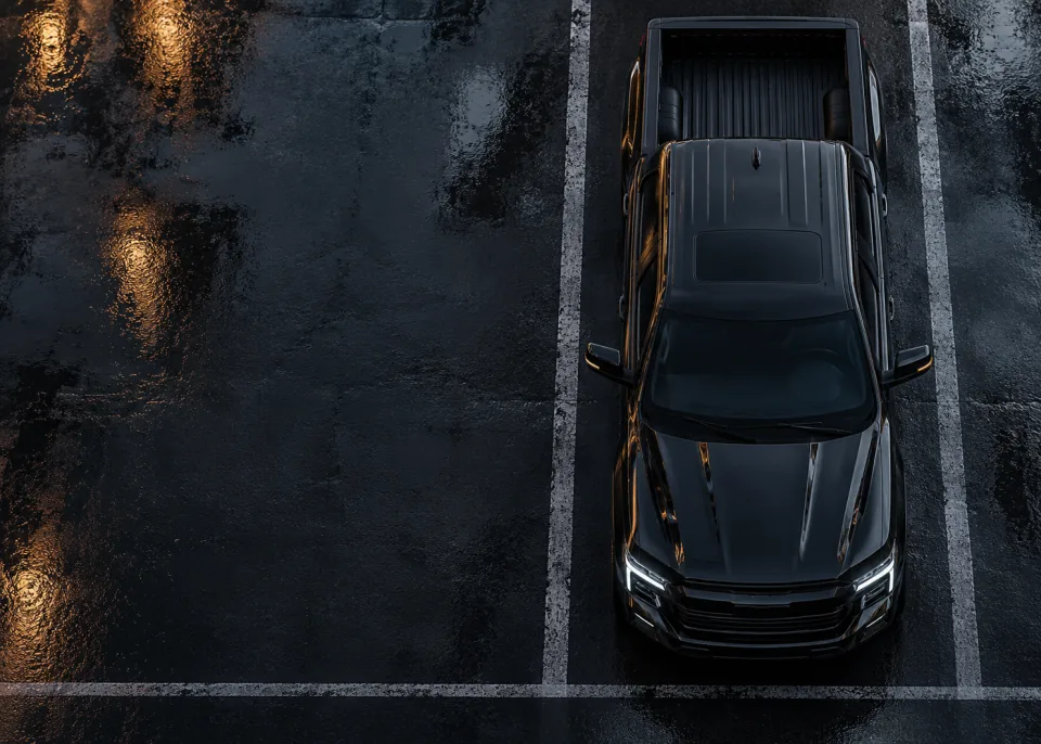 Top Down: Top-down view of a pickup on wet black asphalt with crisp painted parking lines.
