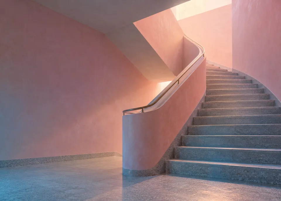 Pink Stairwell: A stairwell with pastel pink walls and soft light from above, the steps turning out of sight.